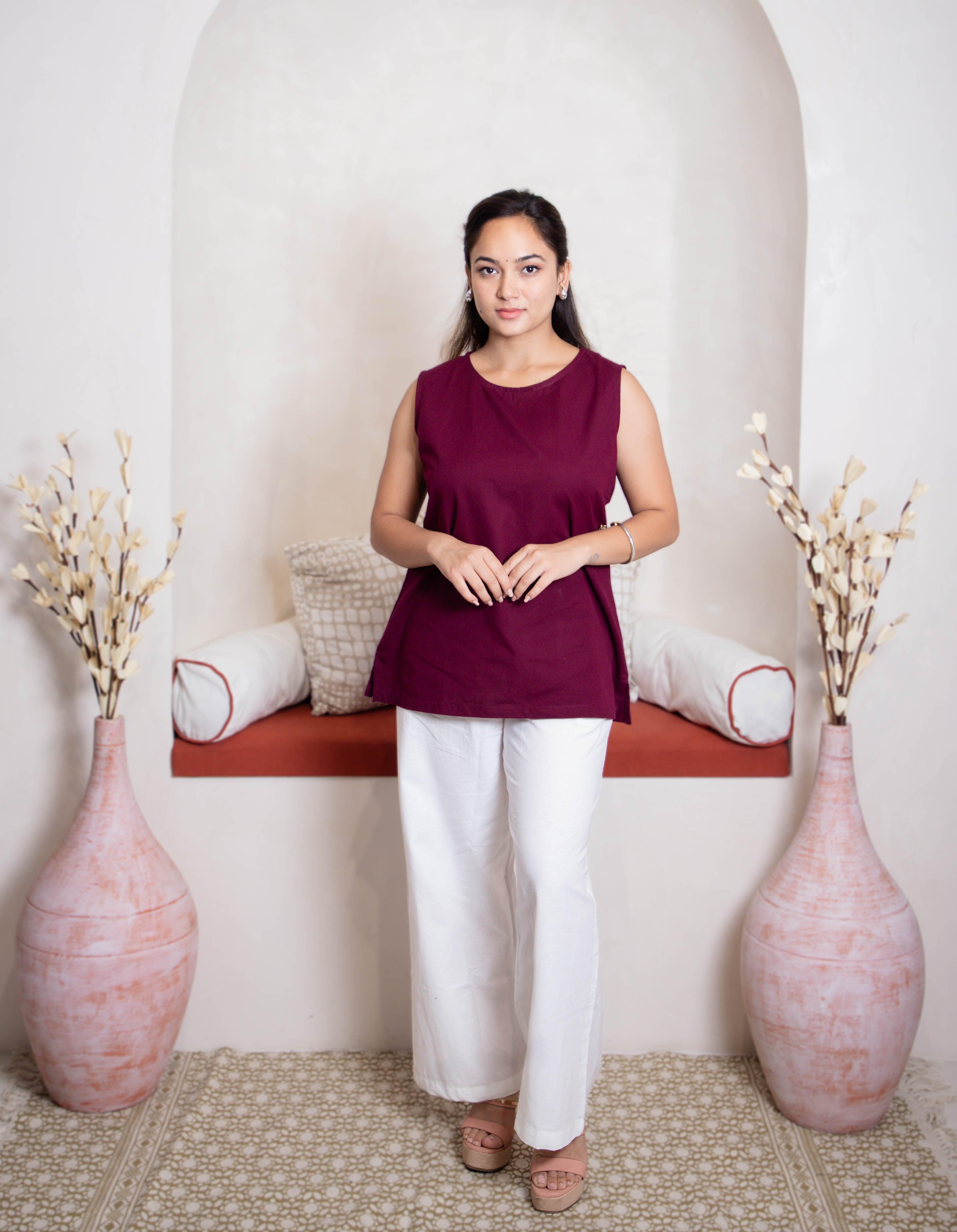girl wearing maroon top and white pants